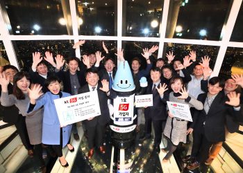 Lota, an AI robot and the first subscriber to KT’s 5G network commercial service, cheers with KT officials at the Lotte World Tower on December 1. PHOTO from KT Corp.