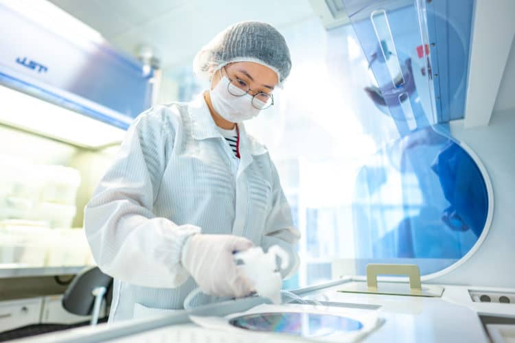 LEES researcher reviewing a 200 mm Silicon III-V wafer.