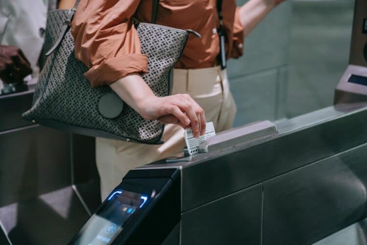 Photo by Liliana Drew: https://www.pexels.com/photo/close-up-of-woman-sliding-the-card-in-a-subway-terminal-8554407/