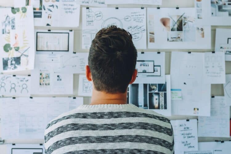 Photo by Startup Stock Photos from Pexels: https://www.pexels.com/photo/man-wearing-black-and-white-stripe-shirt-looking-at-white-printer-papers-on-the-wall-212286/