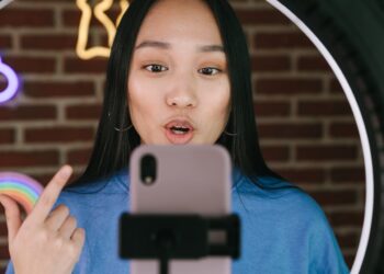 Photo by Ivan Samkov: https://www.pexels.com/photo/a-woman-recording-herself-with-a-smartphone-7676409/