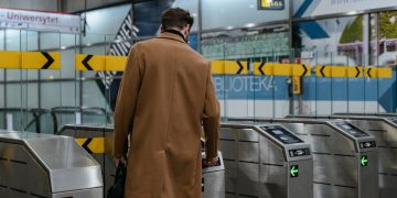 Photo by MART  PRODUCTION from Pexels: https://www.pexels.com/photo/a-person-in-brown-coat-entering-a-subway-automated-ticket-barrier-7251095/