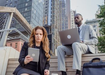 Photo by Mizuno K: https://www.pexels.com/photo/low-angle-shot-of-office-workers-sitting-on-wooden-steps-in-a-city-and-using-portable-devices-13801590/