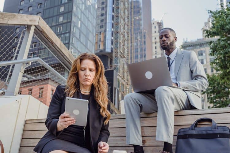 Photo by Mizuno K: https://www.pexels.com/photo/low-angle-shot-of-office-workers-sitting-on-wooden-steps-in-a-city-and-using-portable-devices-13801590/