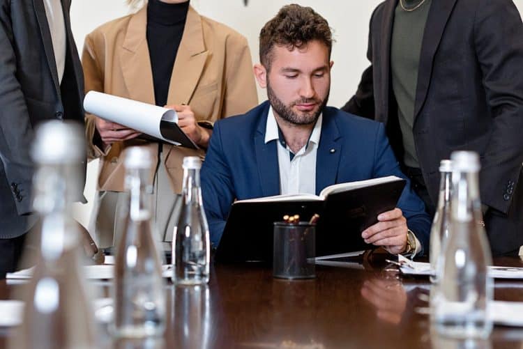 Photo by Mikhail Nilov: https://www.pexels.com/photo/businessman-in-suit-while-reading-a-book-8730174/