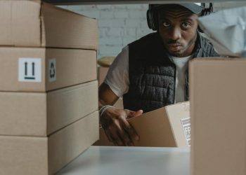 Photo by Tima Miroshnichenko: https://www.pexels.com/photo/a-man-standing-behind-a-shelf-with-cardboard-boxes-6170408/