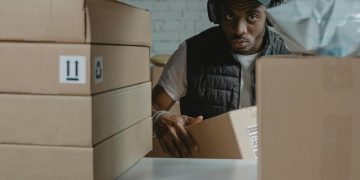 Photo by Tima Miroshnichenko: https://www.pexels.com/photo/a-man-standing-behind-a-shelf-with-cardboard-boxes-6170408/