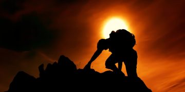 Photo by stein egil liland: https://www.pexels.com/photo/sun-over-silhouette-of-man-rock-climbing-20040806/