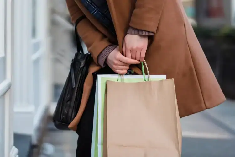 Photo by Tim Douglas from Pexels: https://www.pexels.com/photo/woman-in-coat-standing-with-paper-bags-in-hands-6567651/